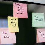 Colorful sticky notes with motivational messages on a mirror reflecting positivity.